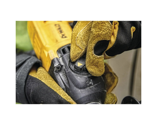 Detailaufnahme einer Person, die mit Schutzhandschuhen einen Winkelschleifer bedient