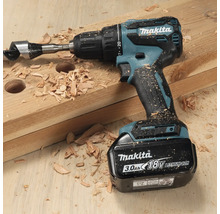 Akkubohrmaschine von Makita mit Holzbohrer auf einem Holzbrett