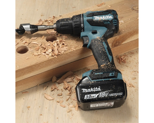 Akkubohrmaschine von Makita mit Holzbohrer auf einem Holzbrett