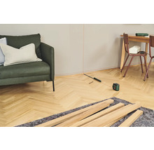 Raumansicht mit Nivellierlaser, Holzleisten und Möbeln für Renovierungsarbeiten