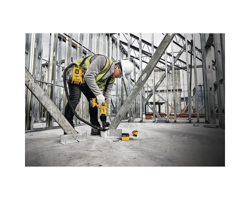 Ein Bauarbeiter verwendet einen Bolzensetzer in einem Rohbau.