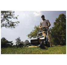 Ein Mann mäht Rasen mit einem Rasenmäher der Marke DeWalt.