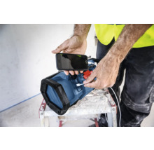 Eine Person lädt ein Mobiltelefon mit einer Arbeitsleuchte auf.