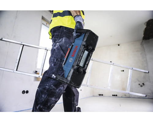 Handwerker trägt Baustellenradio von Bosch in einem Raum mit Leiter