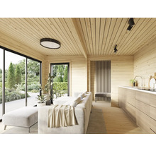 Helles Wohnzimmer mit Holzvertäfelung, Sofa, Küche und großen Fenstern mit Blick in den Garten.