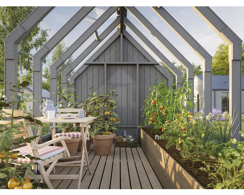 Gewächshaus mit Tisch, Stühlen und bepflanzten Hochbeeten