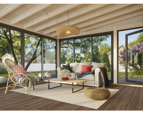 Wohnzimmer mit Rattansessel, Sofa, Couchtisch und Blick in den Garten