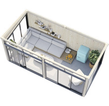 Innenansicht eines Gartenhauses mit Ecksofa, Tisch, Regalen und Dekoration