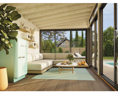 Helles Wohnzimmer mit Ecksofa, Tisch, Kühlgerät der Marke Smeg und Blick in den Garten