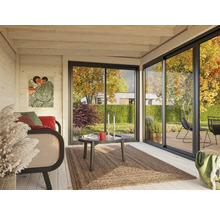 Helles Blockhaus Interieur mit Sofa, Teppich und Schiebetür zum Garten