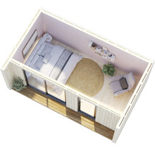 Ansicht von oben eines kleinen Schlafzimmers mit Bett, Sessel und rundem Teppich.