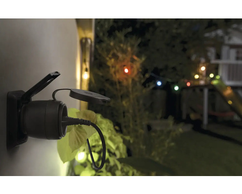 Außensteckdose mit eingestecktem Stecker im Garten