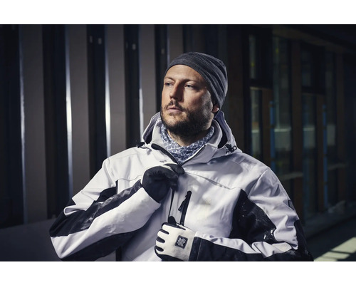 Mann in Arbeitsjacke mit Kapuze, Mütze und Handschuhen