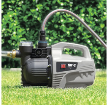 Gartenpumpe auf Rasen mit angeschlossenen Schläuchen