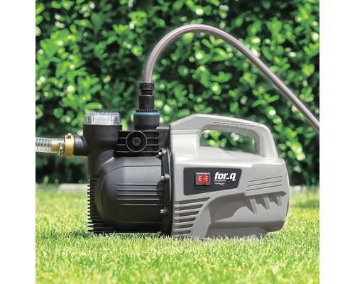 Gartenpumpe auf Rasen mit angeschlossenen Schläuchen