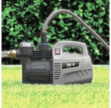 Gartenpumpe auf Rasen mit angeschlossenem Schlauch