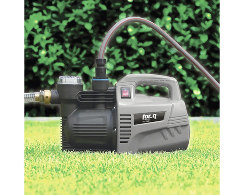 Gartenpumpe auf Rasen mit angeschlossenem Schlauch