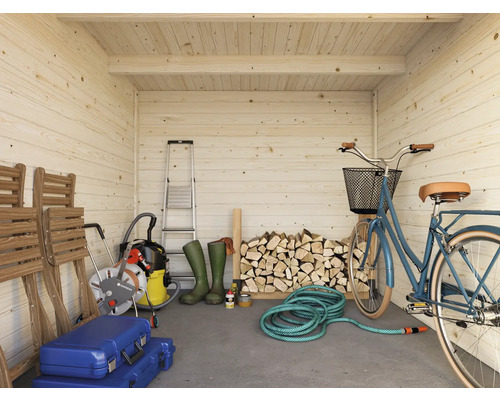 Innenansicht eines hellen Holzgartenhauses mit Leiter, Holzscheiten, Fahrrad und Gartengeräten