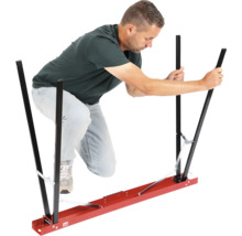 Mann bedient eine Tragehilfe für Gipsplatten