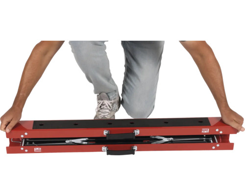 Person kniet auf einem Motorradheber von Cargo Point