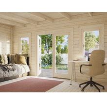 Innenansicht eines Holzgartenhauses mit Bett, Schreibtisch und Blick in den Garten