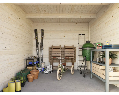 Innenansicht eines Holzhauses mit Gartengeräten, Grill und Skiausrüstung