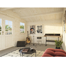 Innenansicht eines Gartenhauses, das als Musikstudio genutzt wird, mit Gitarre, Keyboard und Postern