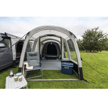 Campingplatz mit aufblasbarem Zelt, Campingmöbeln und Campingausrüstung auf einer Rasenfläche.