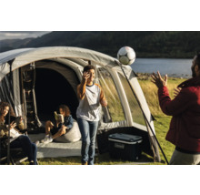 Familiencampingplatz mit Zelt, Kühlbox und spielenden Personen