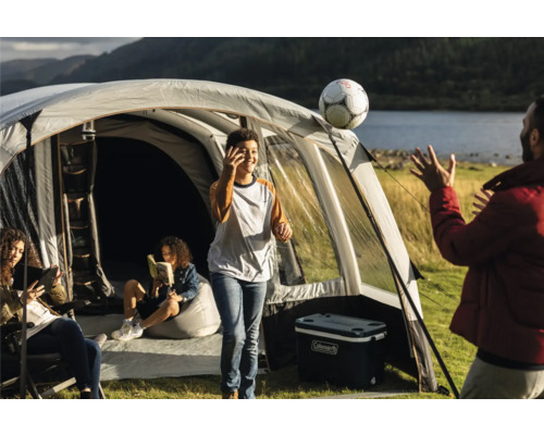 Familiencampingplatz mit Zelt, Kühlbox und spielenden Personen