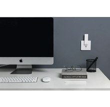 Arbeitsplatz mit Computer, Tastatur, Maus und Ladestation an der Wand