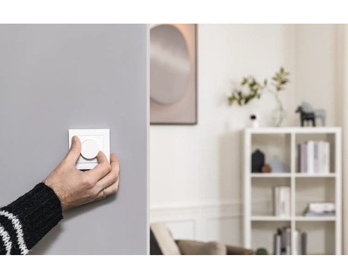 Person bedient Dimmer im Wohnraum