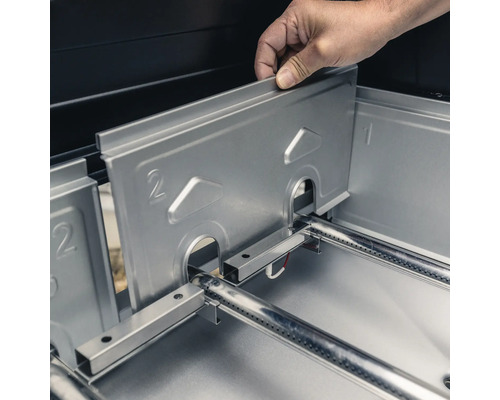 Einsetzen einer Brennerabdeckung in einen Grill