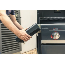 Eine Person setzt eine Powerbox in einen Gasgrill von Campingaz ein.