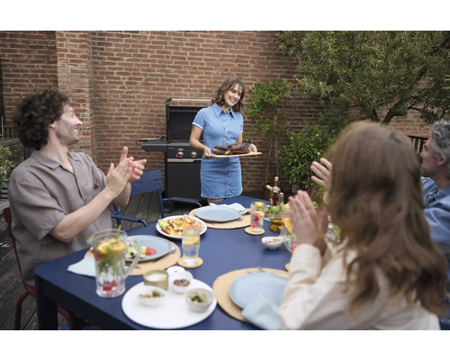 Szene einer Grillparty im Garten mit Grill, Tisch und applaudierender Gesellschaft.