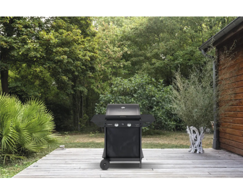 Gasgrill im Garten auf Holzterrasse mit Bäumen im Hintergrund