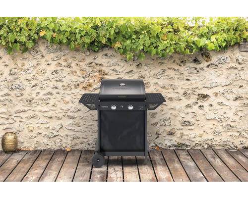 CampinGaz Gasgrill mit zwei Brennern und Seitentischen vor Steinmauer