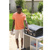 Mann mit Grill im Garten, der einen Grillhandschuh hält