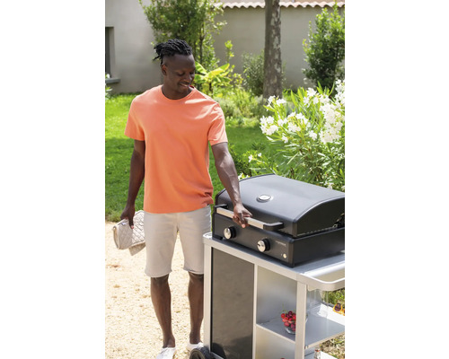 Mann mit Grill im Garten, der einen Grillhandschuh hält