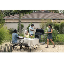 Szene im Garten mit Tisch, Stühlen, Grill und mehreren Personen