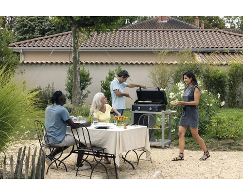 Szene im Garten mit Tisch, Stühlen, Grill und mehreren Personen
