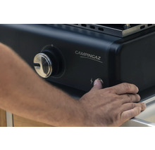 Person drückt Zündknopf eines Campingaz Grills