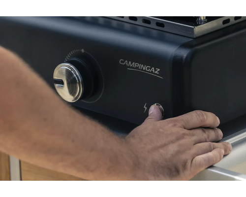 Person drückt Zündknopf eines Campingaz Grills