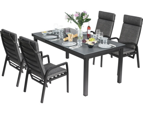 Gartengarnitur mit Esstisch und vier Stühlen aufgedeckt mit Geschirr, Gläsern und Speisen