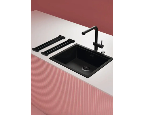 Schwarze Küchenspüle mit Armatur und Ablage auf einer Arbeitsplatte