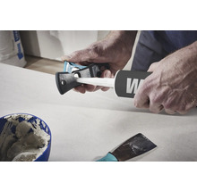 Handwerker benutzt ein Kartuschenmesser, um eine Kartusche zu öffnen.