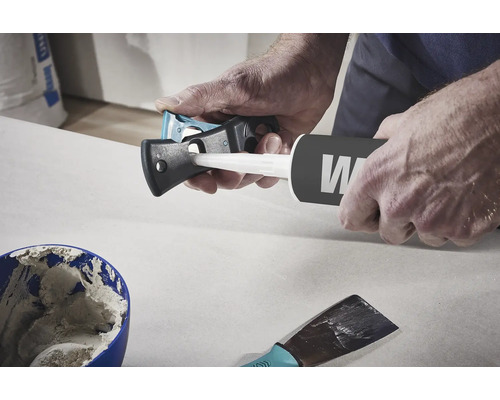 Handwerker benutzt ein Kartuschenmesser, um eine Kartusche zu öffnen.