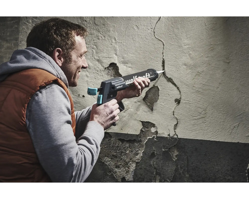 Mann, der eine Rissfüllpistole von Wolfcraft verwendet, um einen Riss in einer Wand zu füllen.