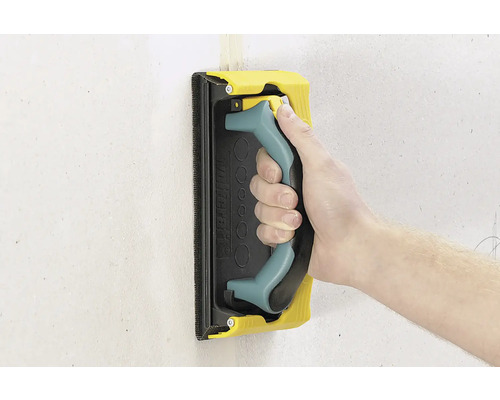 Hand mit Schleifigel zum Schleifen einer Wand