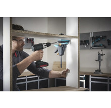 Ein Mann montiert ein Regal mit einem Akku-Bohrschrauber und einer Einhandzwinge.